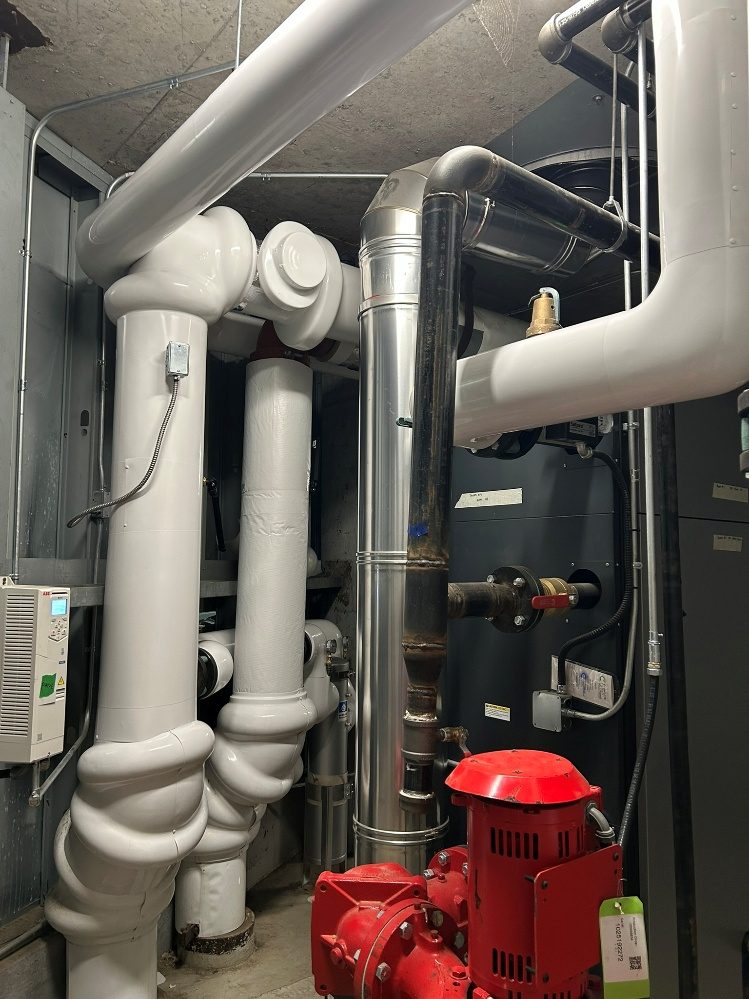 Insulated mechanical room piping beside a pump