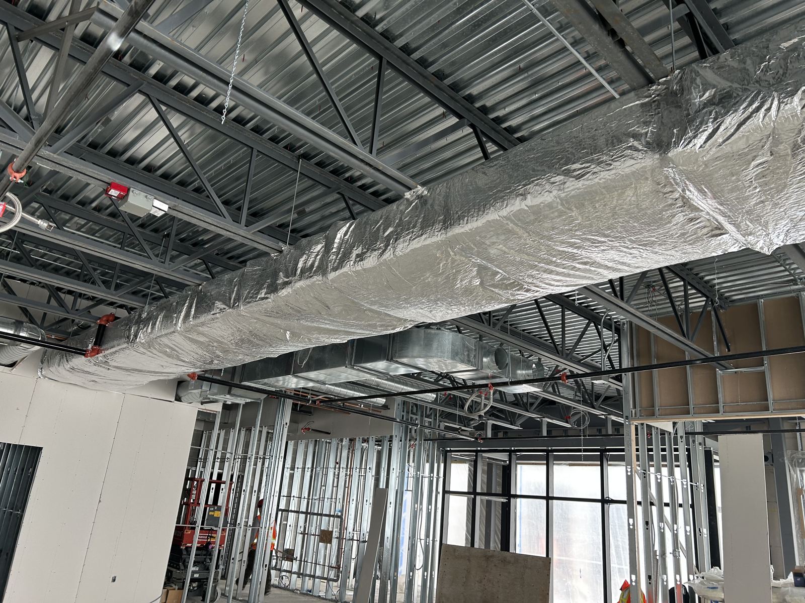 Long interior duct run insulated through an open ceiling