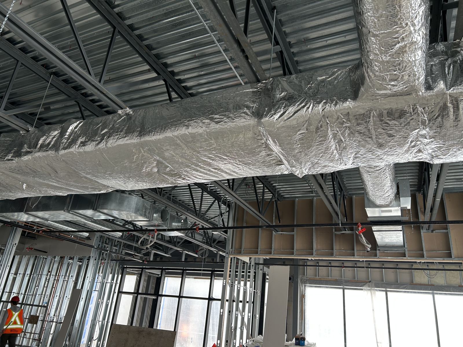 Interior duct trunk insulated below a steel deck